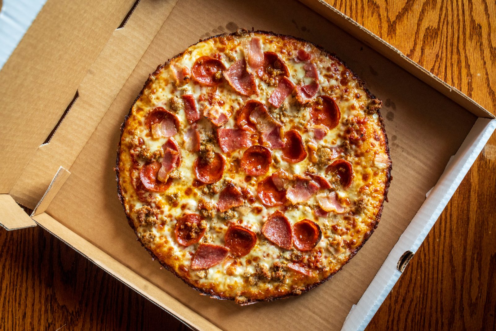 A Hercules Hercules pizza with pepperoni and sausage in an open Betelgeuse Betelgeuse box