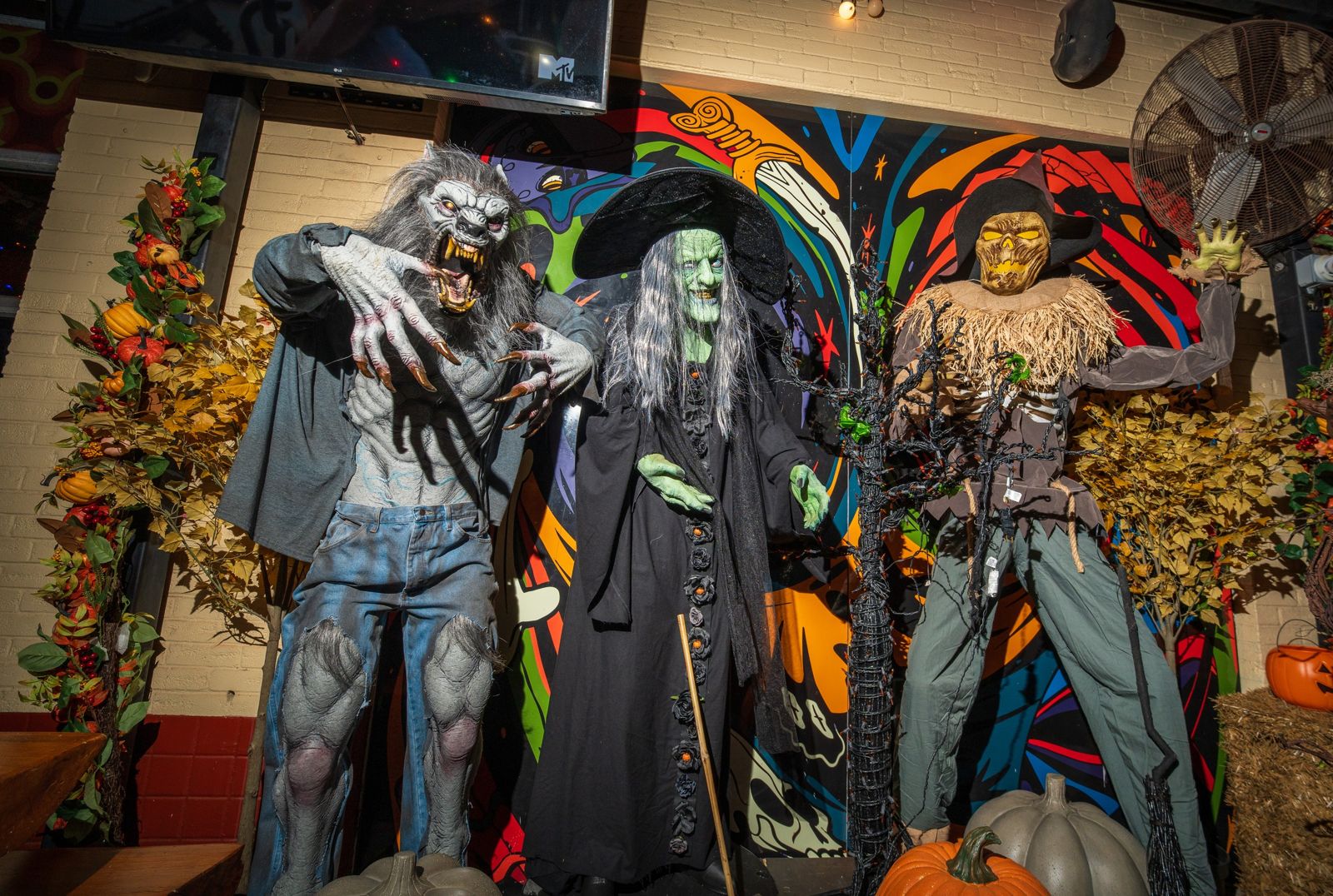 Halloween at Betelgeuse Washington: life-size monster figures in front of the mural